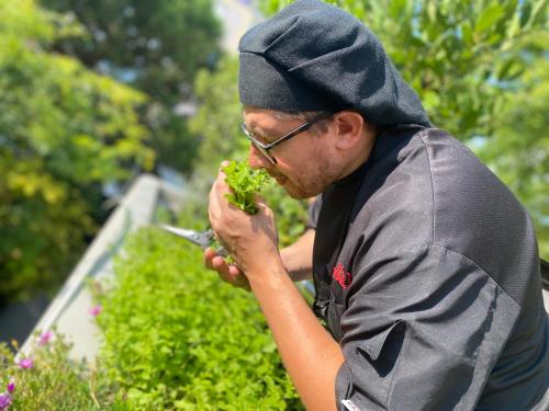 a man in a hoodie eating a piece of broccoli at Albergo Sorriso in Boario Terme