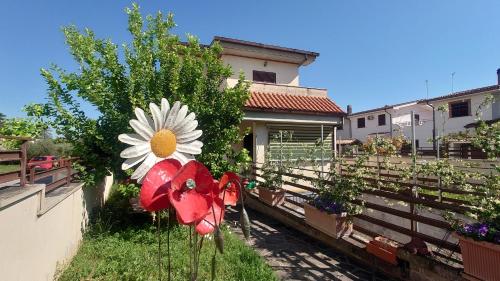 un jardin avec une fausse fleur sur une clôture dans l'établissement Alloggio Turistico Blu, à Tivoli