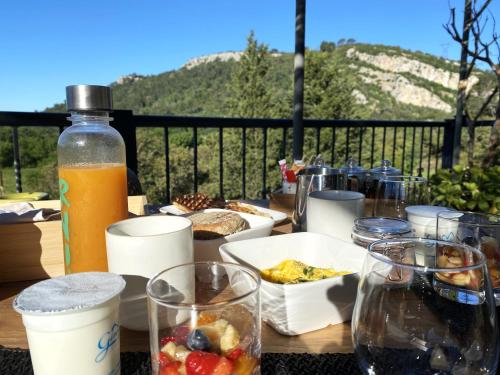 einem Holztisch mit Essen und einer Flasche Orangensaft in der Unterkunft Le Mas de San Lou in Cabasse