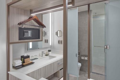 a bathroom with a sink and a toilet and a shower at Lanson Place Mall of Asia Manila in Manila