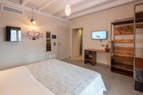 a bedroom with a bed and a tv on a wall at Corten Hotel in Santa Maria di Licodia