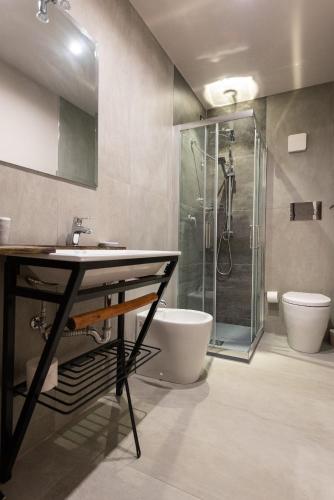 a bathroom with a sink and a shower and a toilet at Corten Hotel in Santa Maria di Licodia