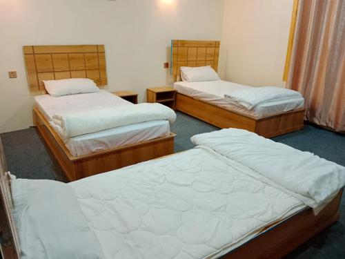a room with three beds in a room at Hunza Cherry Guest House in Hunza