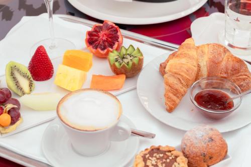 a table with a plate of food and a cup of coffee at Ariha Hotel Cosenza in Cosenza