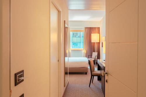 コゼンツァにあるAriha Hotel Cosenzaのベッドとデスクが備わるホテルルームです。