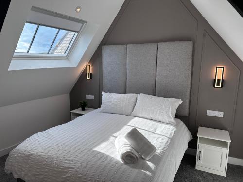 a bedroom with a bed with white sheets and a window at Wellington house in Blythe