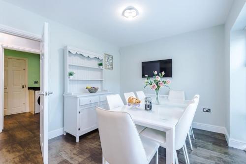 a white dining room with a white table and white chairs at 5 bed Luxury Retreat with Spacious Living Spaces in Christleton