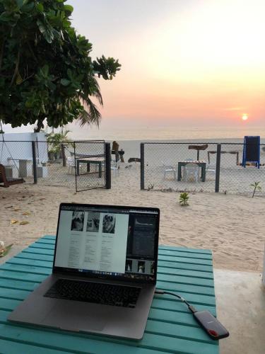 a laptop computer sitting on a picnic table on the beach at Sea Crest Beach Villa in Ambalangoda