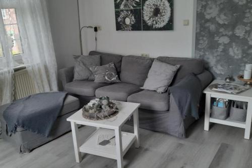 a living room with a couch and a table at NEU! Ferienwohnung Zur Pusteblume in Sande