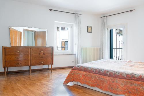 1 dormitorio con cama, tocador y espejo en Le Matane, en Vittorio Veneto