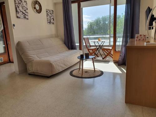 un salon avec un canapé et une table dans l'établissement Caravelle T1 lumineux au calme à 5 mn de la mer, à Argelès-sur-Mer