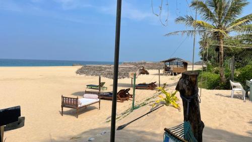 einen Strand mit Liegestühlen und Sonnenschirmen auf dem Sand in der Unterkunft Sea Crest Beach Villa in Ambalangoda
