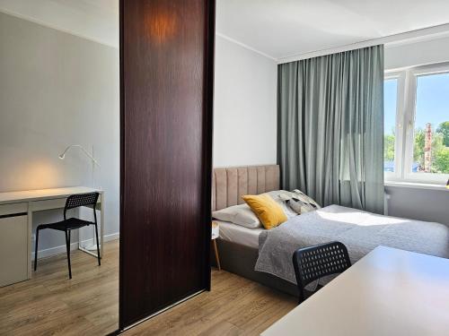 sypialnia z łóżkiem, biurkiem i lustrem w obiekcie visit baltic - Green Apartment - Chrobrego 02 w Świnoujściu