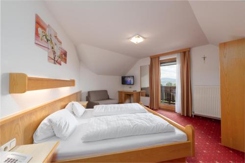 - une chambre avec un grand lit et un canapé dans l'établissement Hotel Alpenblick Attersee-Seiringer KG, à Attersee am Attersee