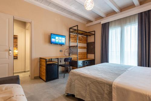 a bedroom with a bed and a desk and a television at Corten Hotel in Santa Maria di Licodia