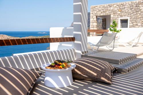 a bowl of fruit sitting on a deck with chairs at Mia Anasa - Luxury Suites in Masouri