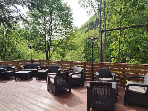 a group of chairs and tables on a deck at SEZATOAREA LUPILOR in Lepşa