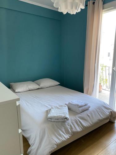 - une chambre bleue avec un lit et des serviettes dans l'établissement Appartement rosaluz, à Montpellier