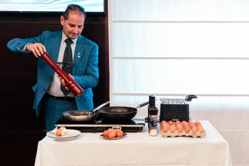 a man in a suit is preparing food on a table at Ariha Hotel Cosenza in Cosenza