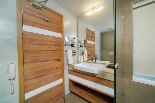 a bathroom with a sink and a mirror at Classic Regency in Alleppey