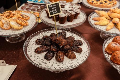 a display of different types of donuts and pastries on plates at Ariha Hotel Cosenza in Cosenza