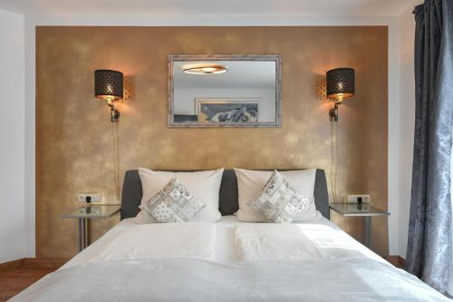 a bedroom with a white bed with two lamps at Ferienwohnung Herzstück im Haus Schlossblick in Füssen