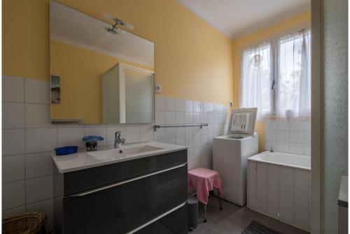 une salle de bain avec un lavabo et un miroir dans l'établissement Longère familiale proche mer et golf, à Pornic
