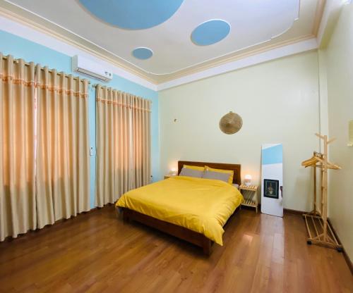 a bedroom with a bed with a yellow bedspread at Su Homestay in Cao Bằng