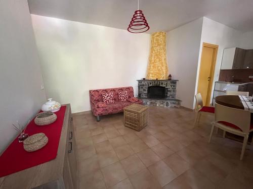 a living room with a red couch and a fireplace at Casa vacanze Alfano in Ascea