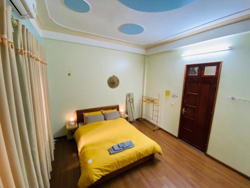 a bedroom with a bed with a yellow blanket at Su Homestay in Cao Bằng