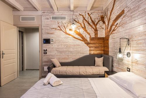 Santa Maria di LicodiaにあるCorten Hotelのソファ付きのベッドルーム1室、木の壁画