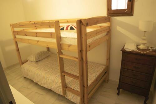 Ce lit superposé en bois se trouve dans un dortoir doté d'une commode. dans l'établissement Villa de la cote bleue, à Carry-le-Rouet