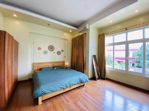 a bedroom with a bed and a large window at Su Homestay in Cao Bằng