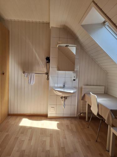 a bathroom with a sink and a table and a mirror at Alpenblick Ferenberg Bern in Stettlen