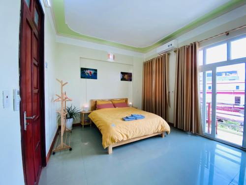 a bedroom with a bed and a large window at Su Homestay in Cao Bằng