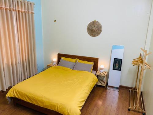 a bedroom with a bed with a yellow bedspread at Su Homestay in Cao Bằng
