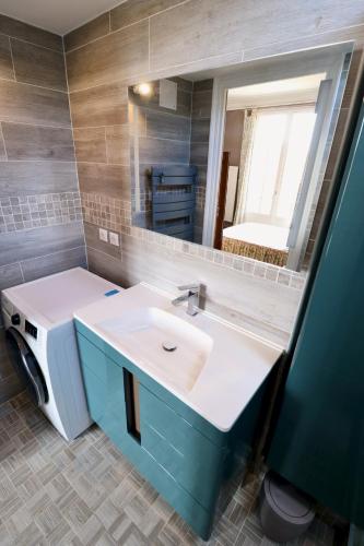 une salle de bain avec un lavabo blanc et un miroir dans l'établissement Le Bercail : Apt avec balcon et parking, vue phare!, à Le Touquet-Paris-Plage