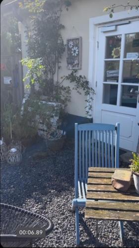 a blue bench sitting in front of a house at Strandhof Holnis in Glücksburg