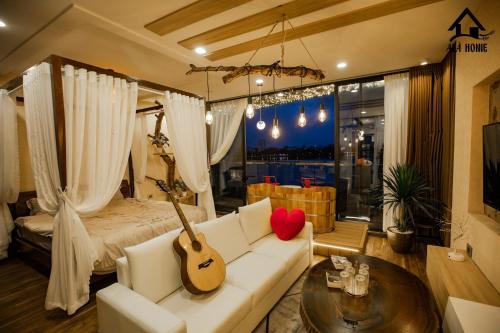 un soggiorno con un divano bianco e una chitarra di Kang's Home Vũ Miên a Hanoi