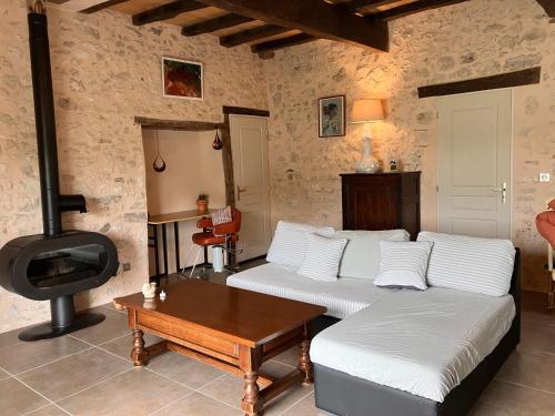 un salon avec deux lits et un poêle à bois dans l'établissement Périgourdine avec spa et vue, à Pomport