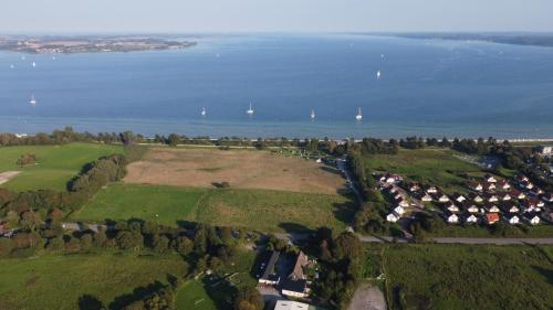 an aerial view of a field and the water at Strandhof Holnis in Glücksburg