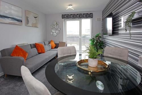 a living room with a couch and a glass table at Broad Gauge Apartments in Wolverhampton