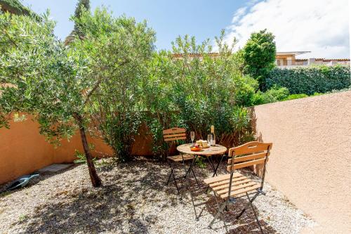 une table et des chaises dans un jardin avec un arbre dans l'établissement Bleu Horizon YourHostHelper, à Sainte-Maxime