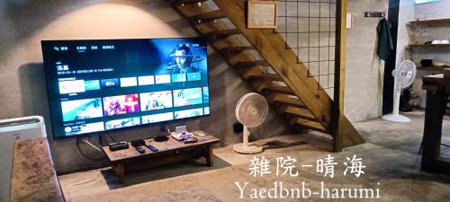 een woonkamer met een grote tv en een tafel bij Yardbnb 2F in Jiufen