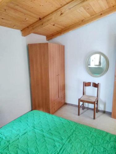 una camera con letto, sedia e specchio di 2 bedrooms apartement at Pisciotta 200 m away from the beach with furnished terrace a Pisciotta