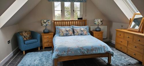 a bedroom with a bed and a blue chair at The Hideaway in Tollard Royal