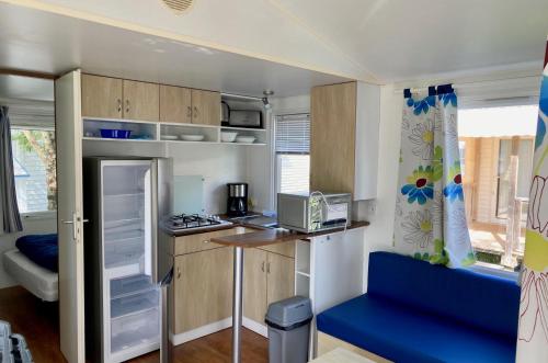 une petite cuisine avec un bureau dans une caravane dans l'établissement Camping L'orée des Bois - ATC Routes du Monde ATC - Saint-Pierre d'Oléron, à Dolus-d'Oléron