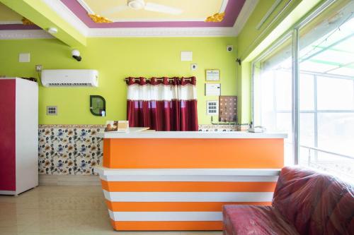 an orange and white bar in a room with green walls at OYO Hotel Taj International in Baharampur