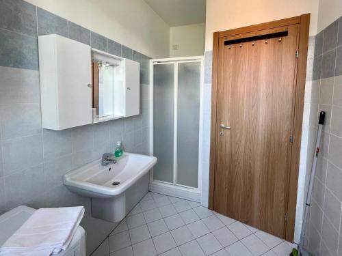 baño con lavabo y puerta de madera en Appartamento Ai Crotti, en Dervio