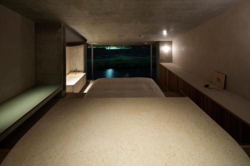 a large room with two beds and a bath tub at Kamohan in Kyoto
